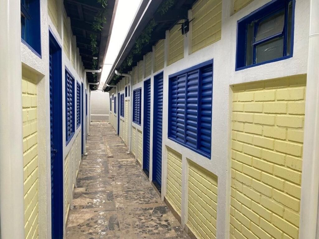 A corridor with lockers on both sides, leading to a door at the end.