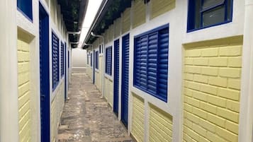 A corridor with lockers on both sides, leading to a door at the end.