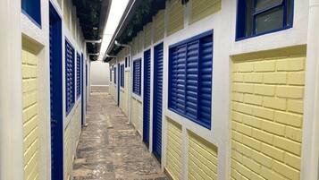 A corridor with doors and windows, leading to a building.