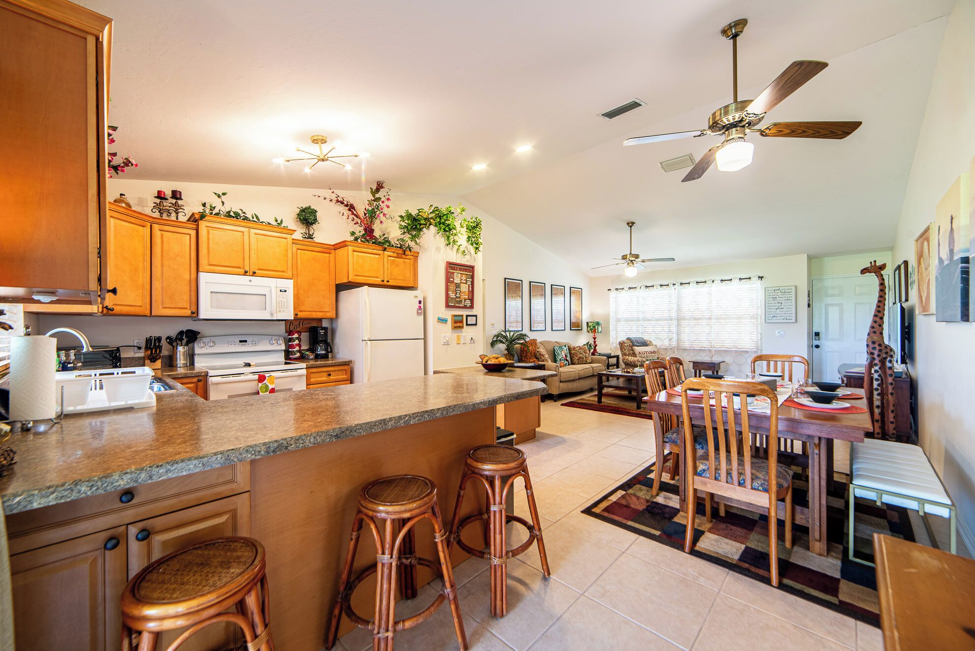 A spacious kitchen with wooden cabinets, a central island, and a dining area with a table and chairs.