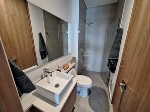 Ein modernes Badezimmer mit Waschbecken, Spiegel und Toilette.