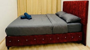 A single bed with a red headboard, grey bedding, and a pair of blue slippers on the footboard. - Cozy Room Near FAC Platz (Vienna)