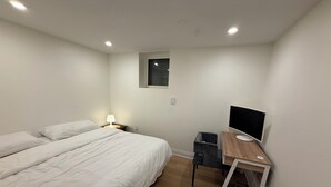 A bedroom with two beds, a desk with a computer, and a window. - Modern Legal Basement Suite with Separate Entrance (Mississauga)