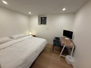 A bedroom with two beds, a desk with a computer, and a window. - Modern Legal Basement Suite with Separate Entrance (Mississauga)