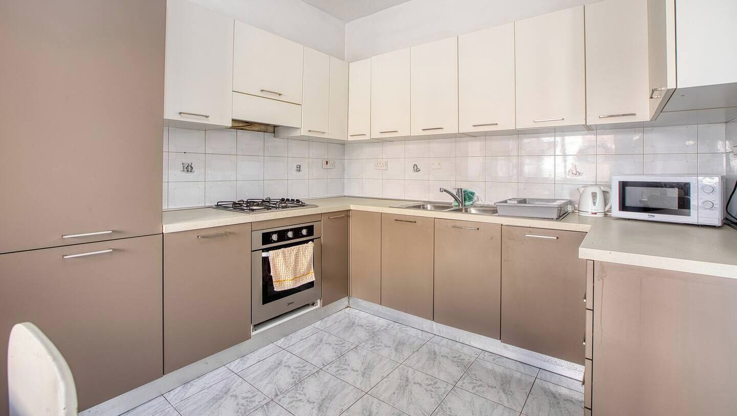 A modern kitchen with a gas stove, oven, microwave, and a sink.