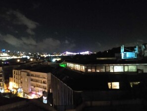 A nighttime cityscape with illuminated buildings and a bridge. - hilltop hostel (fatih istanbul)