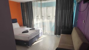 Ein Hotelzimmer mit einem Bett, einer Couch und Blick aus dem Fenster.
