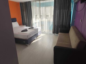 A hotel room with a bed, a sofa, and a view through the window. - hilltop hostel (fatih istanbul)