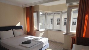 Ein Hotelzimmer mit Bett, Fenster und Heizkörper.