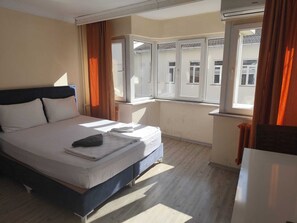 A hotel room with a bed, a window, and a radiator. - hilltop hostel (fatih istanbul)