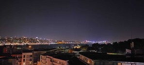 A nighttime cityscape with a bridge and buildings. - hilltop hostel (fatih istanbul)
