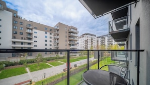 Un balcó amb taula i cadires, amb vista a una zona residencial amb diversos edificis d'apartaments.