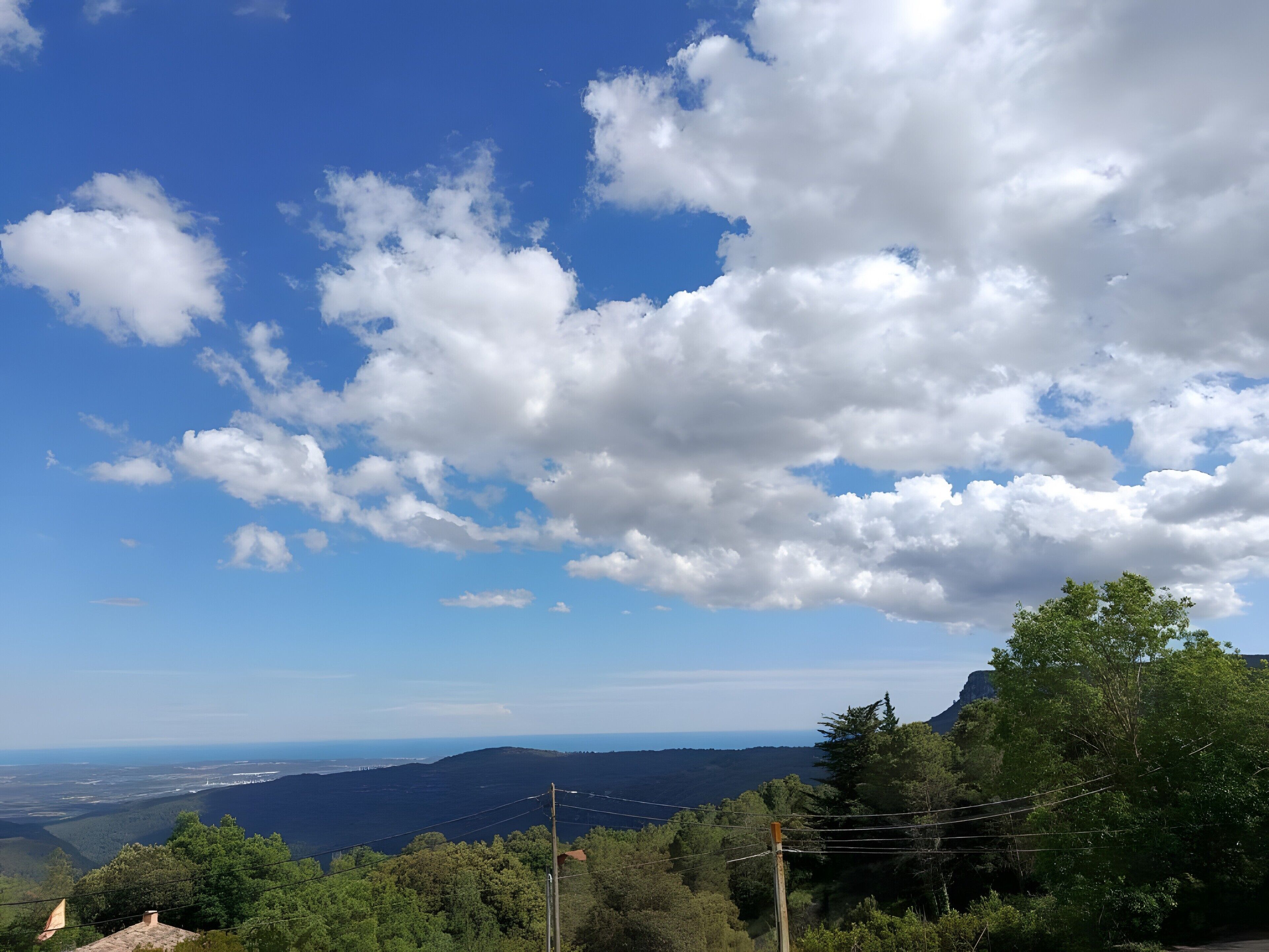 Un paisaje montañoso con cielo despejado y nubes dispersas.