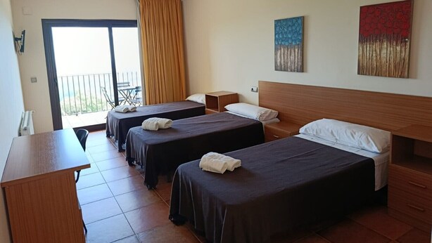 A hotel room with two beds, a desk, and a balcony with a view. - Room 'Habitació Cirerer' with Sea View, Balcony and Wi-Fi (Mont-ral)