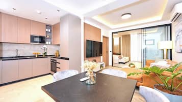 Une chambre d’hôtel moderne dotée d’une cuisine, d’un coin repas et d’un espace de vie.