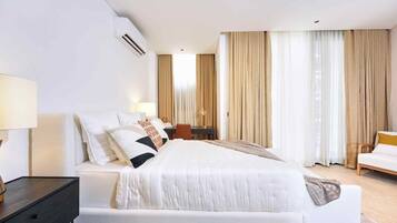 Une chambre d’hôtel avec un grand lit, des tables de chevet, un bureau et une chaise.