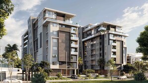 A modern multi-story residential building with balconies, a landscaped garden, and a clear sky. - Bravia Residency - Spring Properties (Accra)