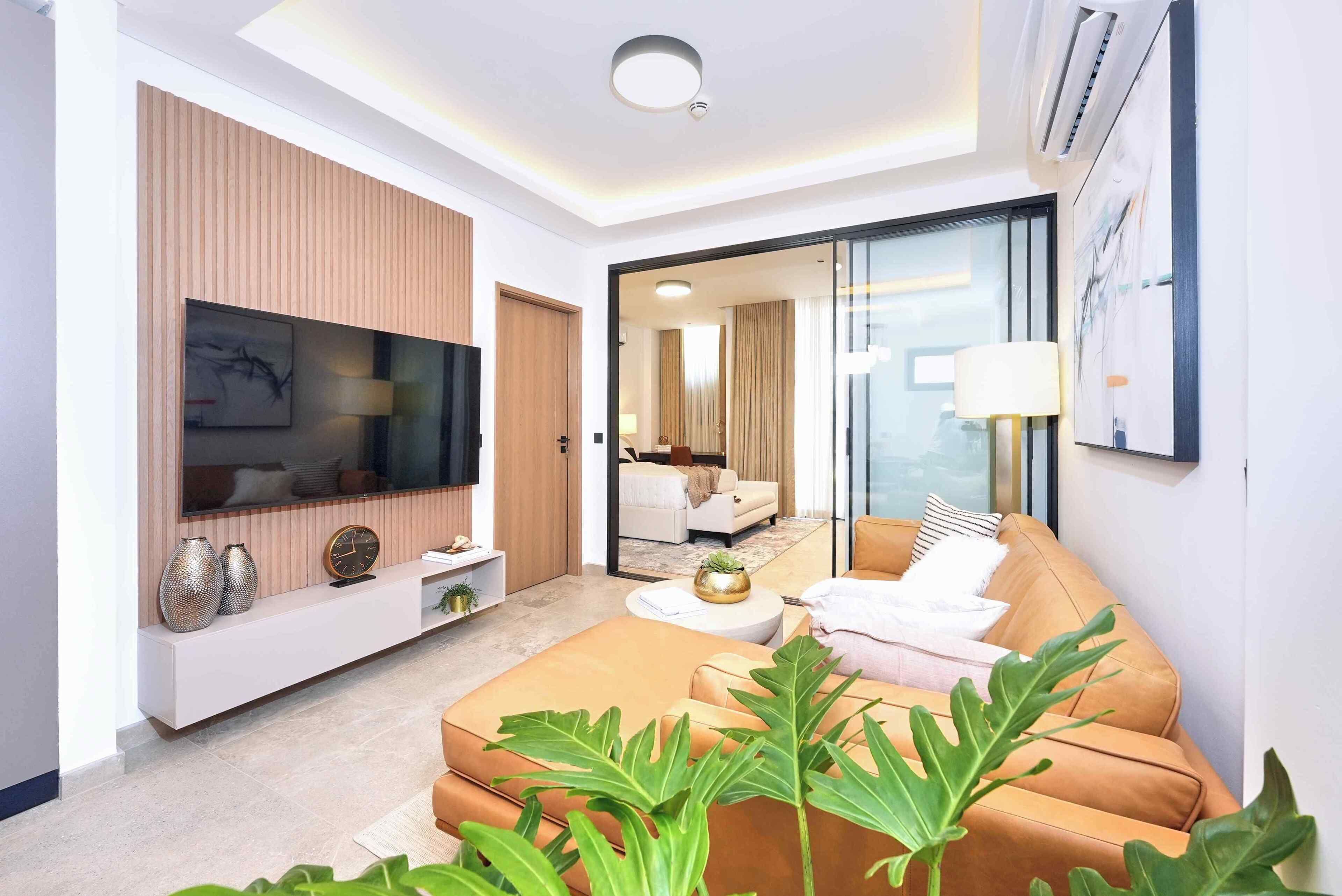 Una sala de estar moderna con una televisión de pantalla plana, un sofá y una mesa de centro.