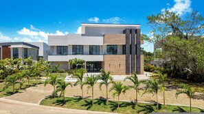 Un bâtiment moderne à deux étages, doté d’un toit plat, de grandes fenêtres et d’une allée pavée.