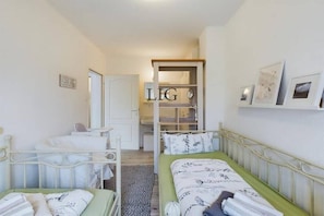 Ein Schlafzimmer mit zwei Betten, einem Kleiderschrank und einem Spiegel.