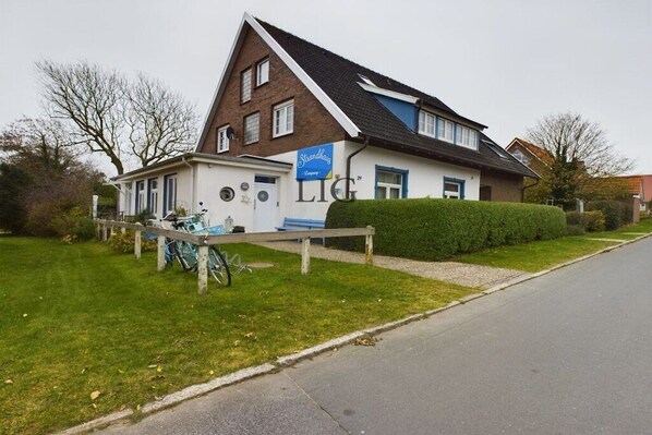 A two-story building with a sign for 'Strandhagens' and a visible entrance. - Holiday apartment Seestern (Langeoog)