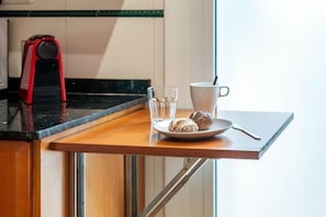 A kitchen counter with a coffee maker, a glass of water, a mug, and a plate with cookies. - Wake up to a view of the Sagrada Familia (Barcelona)