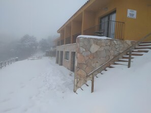 Un edificio con fachada de piedra, una escalera y un balcón.
