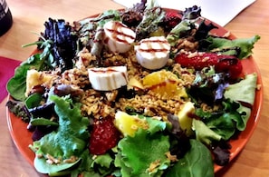 Una ensalada con distintos ingredientes y un plato sobre una mesa.