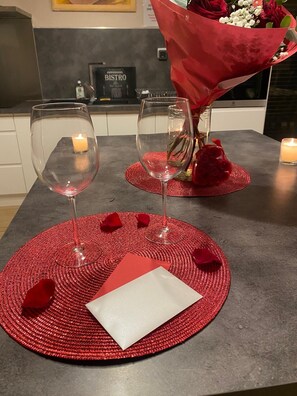 A table set with two wine glasses, a red napkin, and a bouquet of flowers. - Vrbo Property (Agonac)