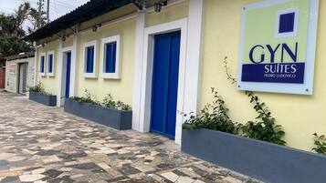 A building with a sign for 'GYN SUITES PEDRO LUDOVICO' and a tiled walkway.
