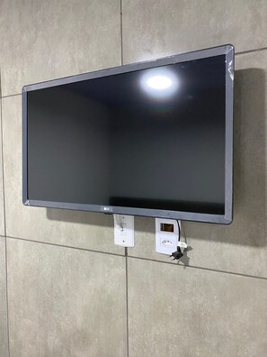 A flat-screen TV mounted on a tiled wall. - Gyn Suítes Pedro Ludovico (Goiânia)