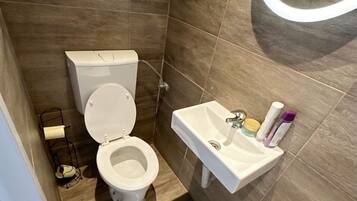 Un baño con inodoro, lavabo y espejo.
