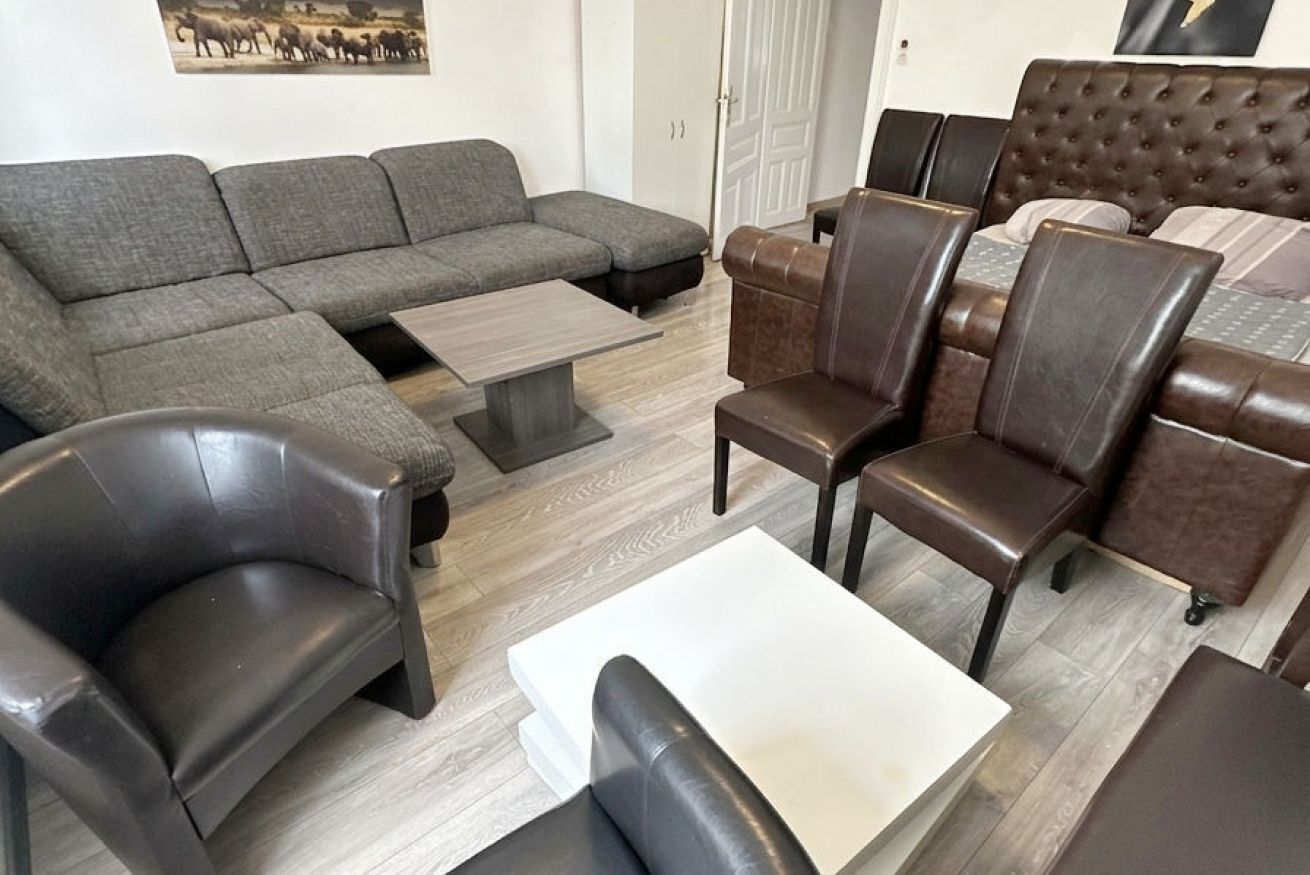 A living room with a sectional sofa, a coffee table, and leather armchairs.