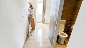 A narrow hallway leading to a bathroom with a toilet and a shower area. - Cozy Studio for 4 Near Floridsdorf (Vienna)