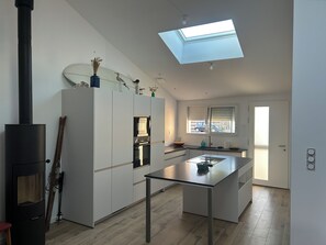 A modern kitchen with a central island, a built-in oven, and a skylight above. - House for rent near Les Conches Beach (700 m) (Longeville-sur-Mer)