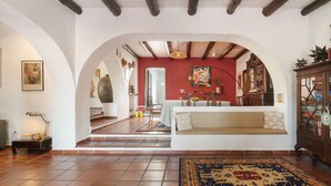 A spacious living area with a sofa, a rug, and a dining table. - 'Excelentíssimo' Holiday Home with Lake View, Wi-Fi, and Air Conditioning (Torrão)