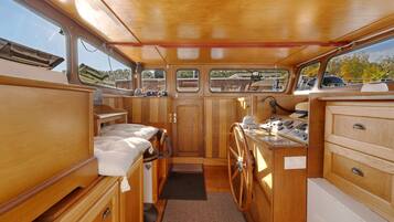 A compact galley with wooden cabinetry, a small sink, and a stove.