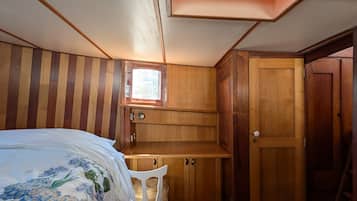 Un dormitorio con cama, escritorio y armario.