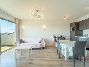 Ein modernes Interieur mit Essbereich, einer Couch und einer Küche.