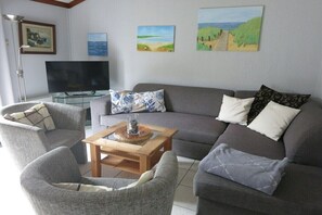 A living room with a sofa, two armchairs, a coffee table, and a flat-screen TV. - Holiday apartment with 2 bedrooms (Bredene)