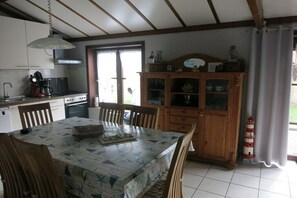 A kitchen with a dining table, chairs, cabinets, and a window. - Holiday apartment with 2 bedrooms (Bredene)