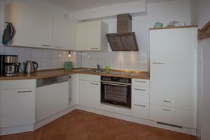A kitchen with white cabinets, a stove, an oven, and a dishwasher. - favorite spot in the thatched house (Putbus OT Wreechen)