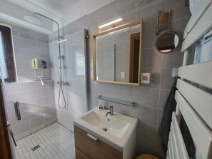 A modern bathroom with a shower, a sink, and a mirror. - Central apartment, balcony, south/east view (Montgenèvre)