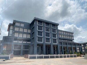 Un edificio de varios pisos con techo plano, ventanas amplias y una entrada con portón.