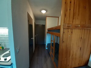 A narrow hallway with a bunk bed on the right, a door at the end, and a window on the left. - Ideal apartment, view - 6 guests (Valfréjus)
