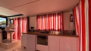 A compact kitchen with a sink, stove, and a small refrigerator.