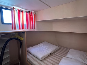 A bunk bed with a window above, a shelf with a yellow hanger, and a closet with a hanging rack. - Unique houseboat in Digoin - 12 guests (Digoin)