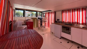 Een compact keuken met een eethoek, een rode tafel en uitzicht door de ramen.