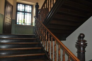 A wooden staircase with a handrail and a window with a plant on the landing. - Holiday apartment in Leipzig with Wi-Fi (Leipzig)