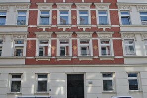 A multi-story building with a symmetrical facade, featuring a central entrance with a black door, and evenly spaced windows on each floor. - Holiday apartment in Leipzig with Wi-Fi (Leipzig)